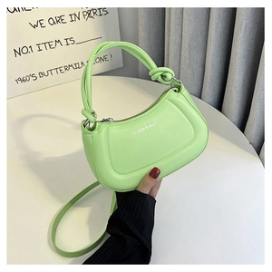Detail of neon green crescent bag with knotted handle and white fashion text logo