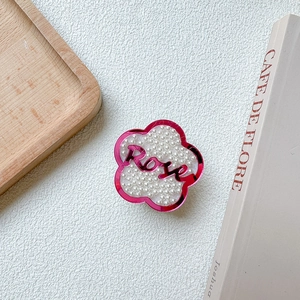 Détail du support téléphone fleur rose avec perles blanches et texte Rose sur blanc