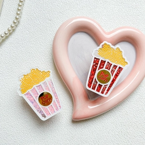 Detailed close-up of popcorn-shaped acrylic phone grip with liquid glitter and sequins