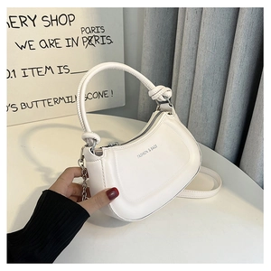 Detail view of a white semi-circular PU leather handbag with elegant knot handle and chain