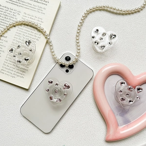 Detail showing heart-shaped rhinestones phone grip in silver and pink crystal finish