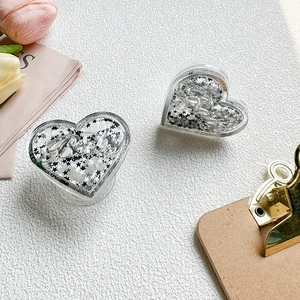 Details des herzförmigen Glitzer-Handyhalters mit schwarzen und silbernen Sternen