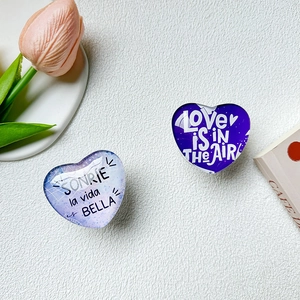 Close-up of heart-shaped glass phone sockets with inspirational quotes on white desk