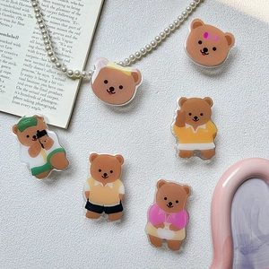 Detail shot of cute acrylic bear phone grips in various outfits on a white background
