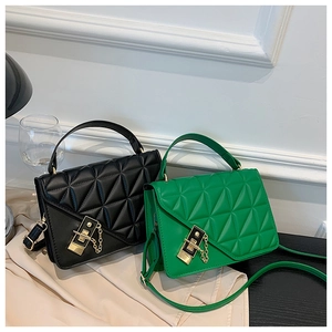 Detail of quilted crossbody bags in black and green with gold metal twist locks