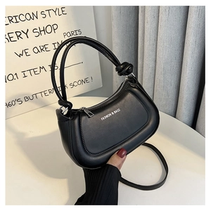 Close-up of black handbag featuring knotted handle detail and Fashion & Bags text