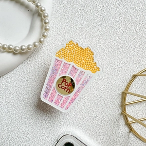 Close-up of glitter-filled popcorn phone socket with pink sequins and Pop Corn label