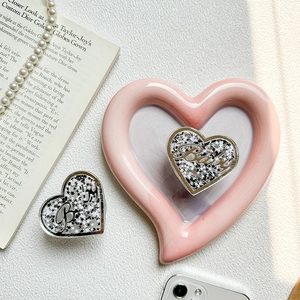 Detail der pinkfarbenen Herz-Handyhalterung mit Glitzer-Sand-Effekt und Baby-Schriftzug