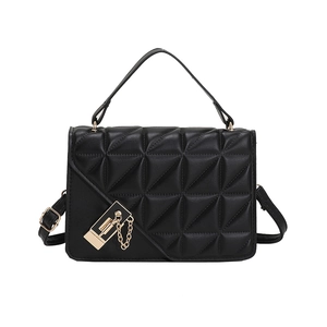 Women's black quilted crossbody bag with gold chain and top handle on white background