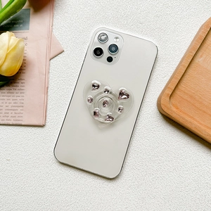 Sparkling pink rhinestone heart phone grip on a white smartphone, 45-degree angle view