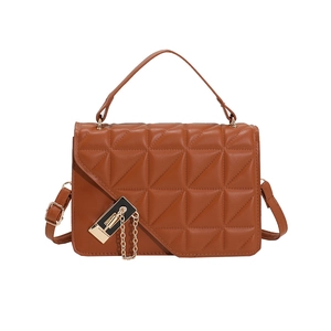 Detail of brown quilted faux leather handbag featuring a geometric pattern and gold clasp