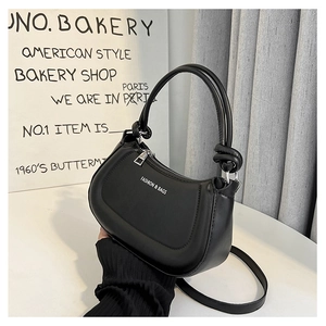 Detail of black PU leather half-moon bag featuring knotted handle and fashion text logo