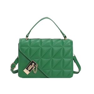 Detail of bright green quilted handbag featuring a distinct geometric clasp and chain