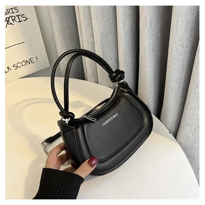 Detail of black PU leather crescent bag with white Fashion & Bags text and chain strap