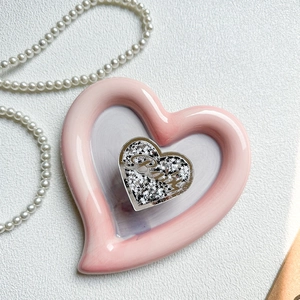 Detail der rosa Herz-Handyhalterung mit silbernen Glitzersternen und Baby-Text