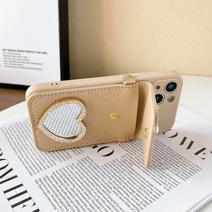 Détail de coque iPhone en cuir matelassé beige avec miroir coeur et porte-cartes