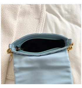 Top view of blue quilted handbag showing black lining and interior zipper compartment