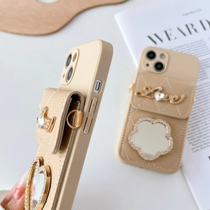 Détail de la coque iPhone crème avec texture matelassée et ornement en diamant Love