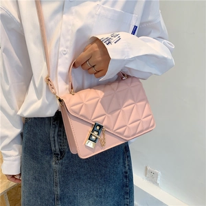 Chic pink quilted crossbody bag with golden lock and chain detail shown on model