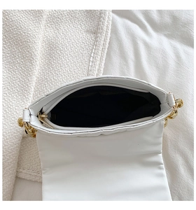 Detail view of white quilted PU bag with internal zipper pocket and gold chain