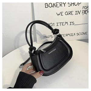 Detail of black leather crescent bag with knot handle and Fashion & Bags printed text