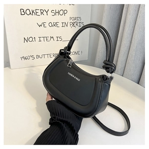 Close-up of knot handle detail and white brand lettering on black hobo shoulder bag