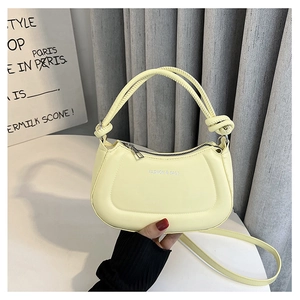 Detailed close-up of cream PU leather handbag with woven knot handle and zipper closure