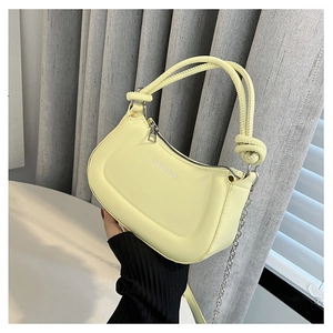 Macro detail of lemon yellow PU bag with fashion lettering and knotted handle