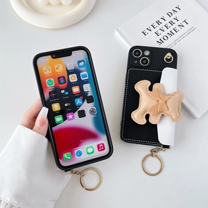 Close-up of leather iPhone case with bear bow card holder and metal hooks for crossbody strap