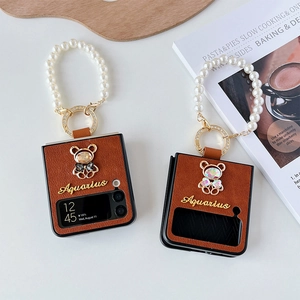 Dettaglio custodia Z Flip in pelle marrone con orsetto di strass e cinturino di perle lussuoso