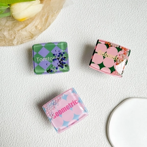 Detail of square acrylic phone grips with colorful quicksand beads and checkerboard patterns