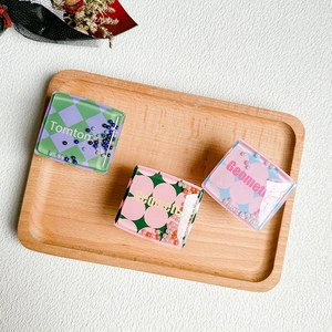 Detailed view of square phone grips with colorful quicksand beads and checkerboard patterns