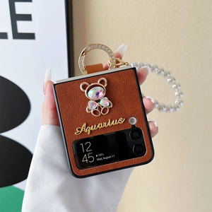 Dettaglio custodia in pelle marrone per Z Flip con orsetto di strass e catena di perle