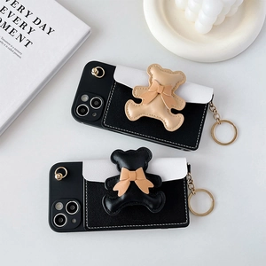 Macro detail of 3D leather bear charm and metal ring hook on a two-tone iPhone case