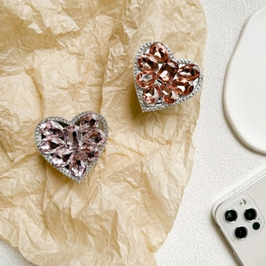 Detailed close-up of heart-shaped rhinestone phone grips in pink and orange gemstone styles