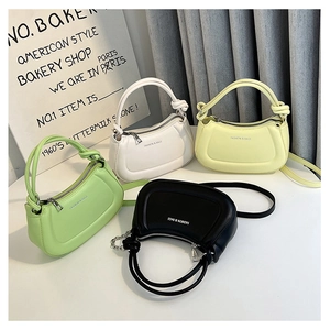 Top view of sleek dumpling bags in green, beige, yellow, and black with chain straps