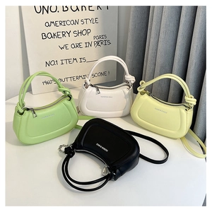 Detail of four colorful half-moon handbags with knotted handles and silver logo accents