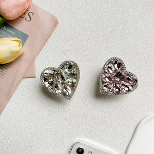 Close-up of heart-shaped phone grip with luxury sparkling rhinestones and pink tulips