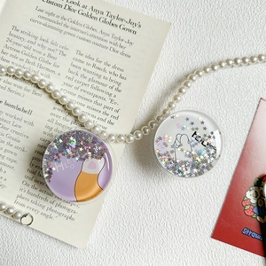 Close-up of circular phone griptok with holographic star sequins and cute cat designs