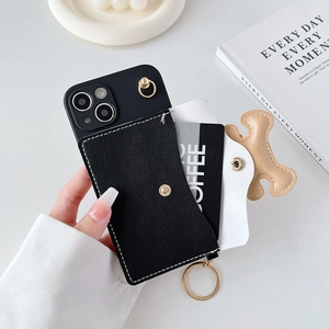 Detail of black leather wallet phone case with cream bone charm and gold ring for iPhone