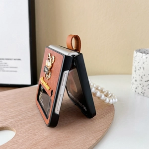 Dettaglio custodia Galaxy Z Flip in pelle con orsetto di strass, testo Sagittario e perle