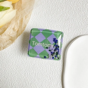 Detailed view of square phone socket with green checkered pattern and colorful moving beads