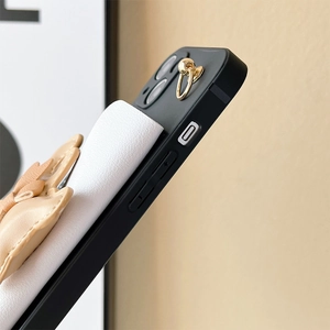 Detail of iPhone 16 case featuring black silicone edge, white card pocket and heart charm