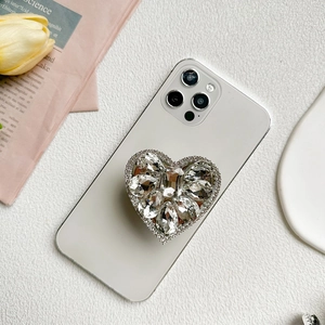 Luxury rhinestone heart phone grip stand on white smartphone with diamond embellishments