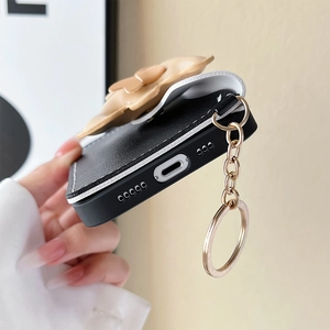 Detail of iPhone 16 black leather wallet case with 3D bear and precise charging cutouts