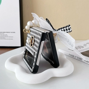 Dettaglio custodia Galaxy Z Flip con motivo pied-de-poule, fiocco in pizzo e perle