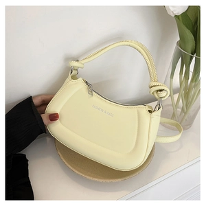 Detail of light yellow crossbody bag with curved design and FASHION & BAGS lettering