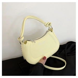 Close-up of yellow half-moon bag featuring a knotted handle and Fashion & Bags text print