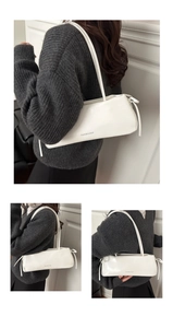 Close-up of white leather baguette bag with Fashion & Bags text on shoulder strap