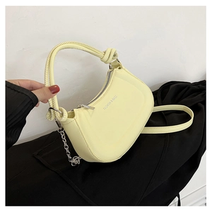 Detail view of yellow crescent bag with knotted handle and fashion lettering